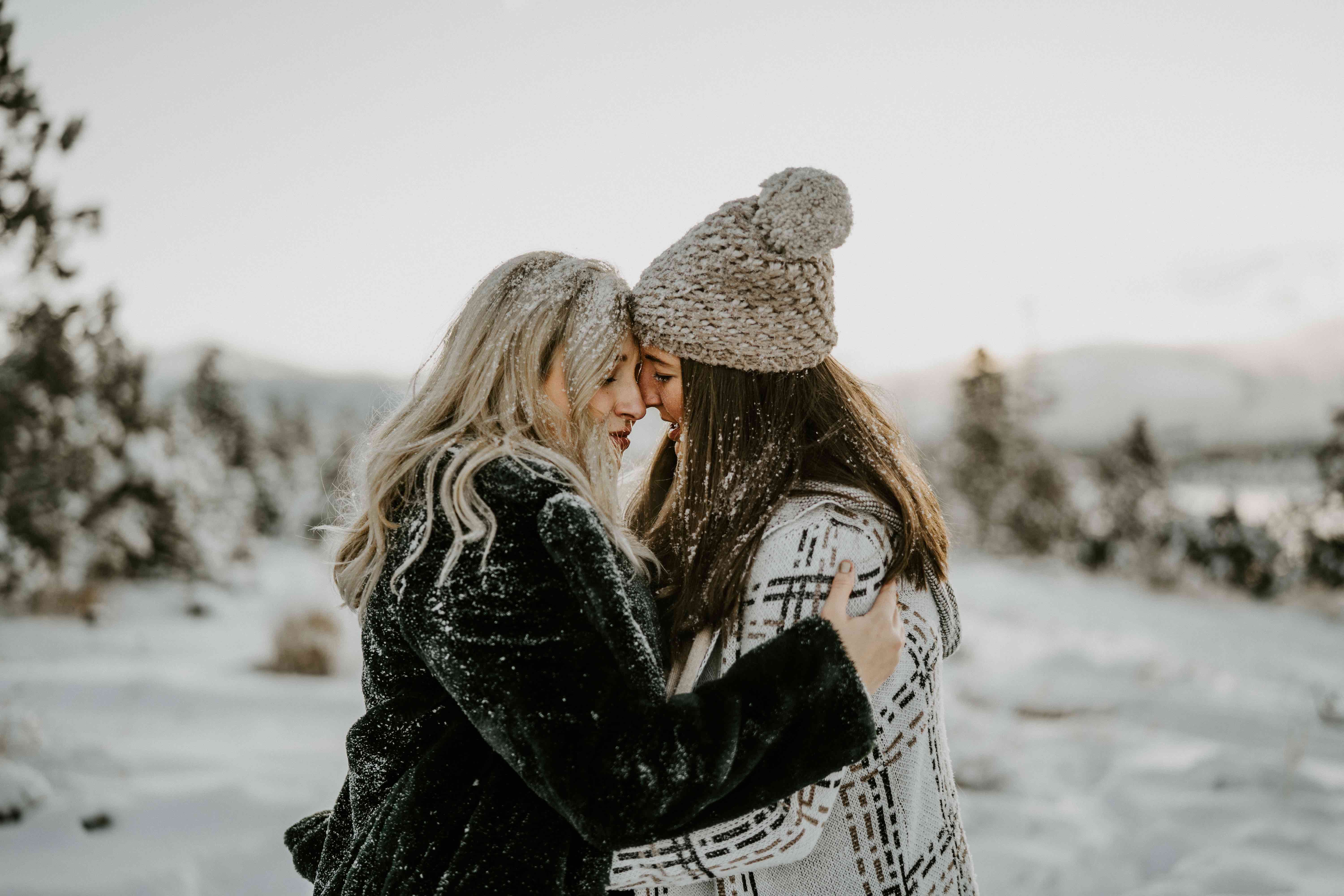 two snow covered women in love embracing