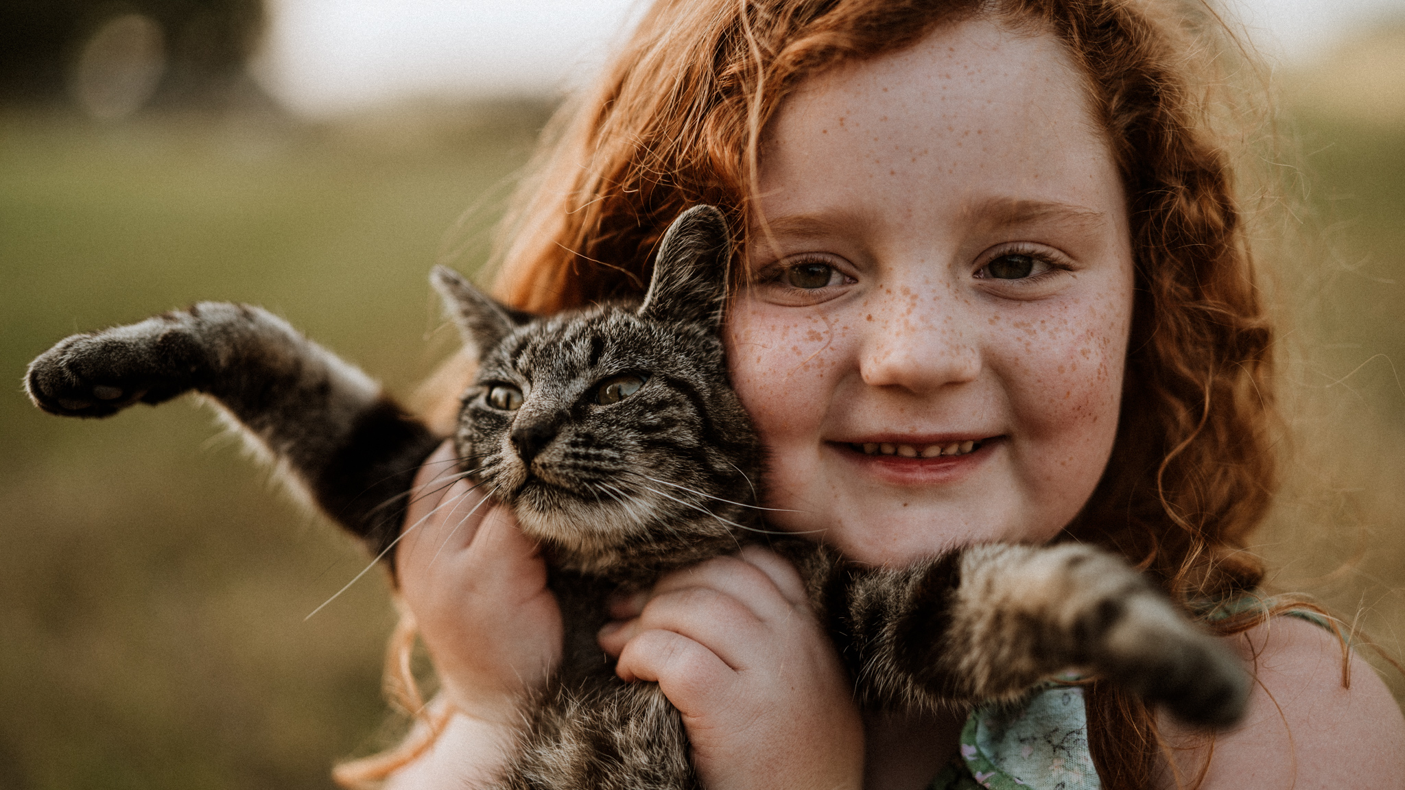 Family Photos at Home; young redheaded girl holding her favorite kitten